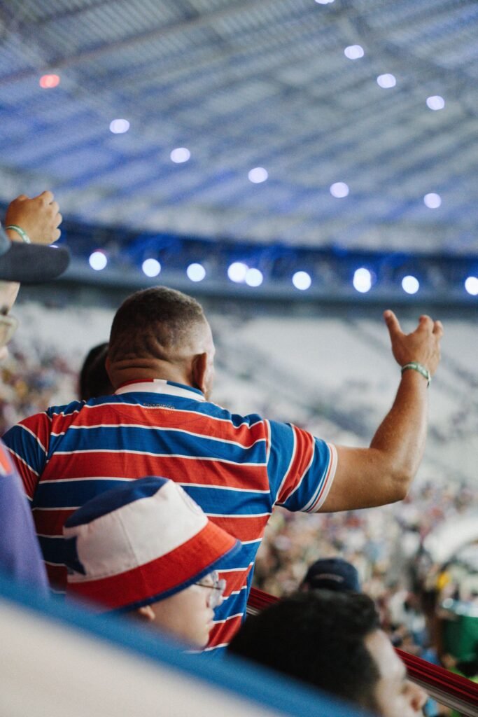 Fans cheering under bright arena lights at night